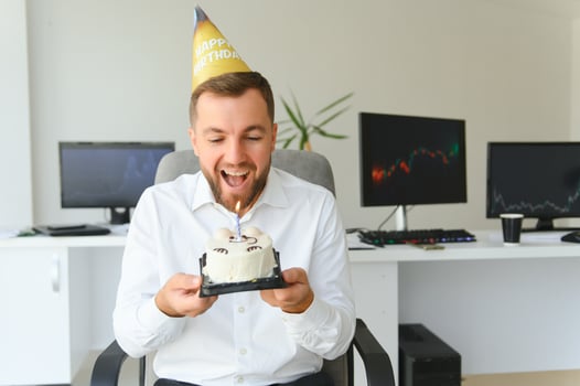 Young businessman celebrating birthday alone in office photo