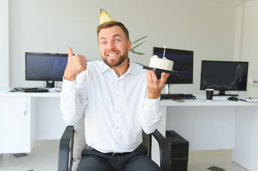 Young businessman celebrating birthday alone in office photo