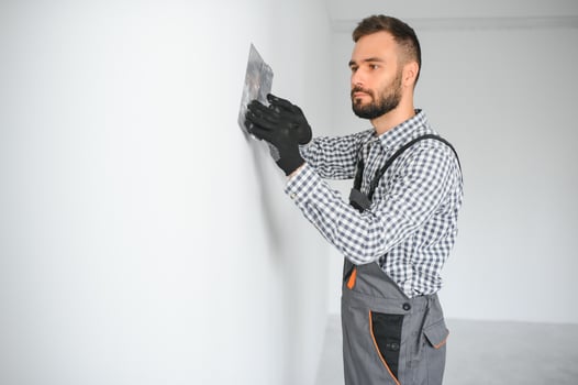 business, building, profession and people concept - builder with grinding tool indoors photo