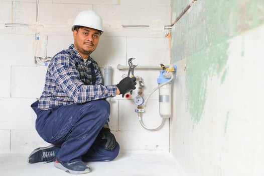 Indian plumber installing water equipment - meter, filter and pressure reducer photo