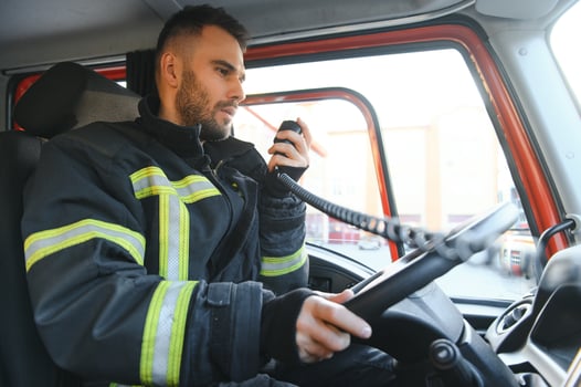 Firefighter using radio set while driving fire truck photo