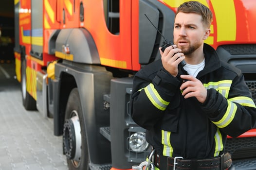 Photo of fireman with gas mask and helmet near fire engine