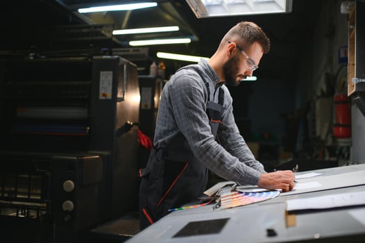 Graphic engineer or worker checking imprint quality in modern print shop photo