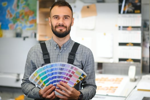 Typographer standing with color swatches at the printing manufacturing photo