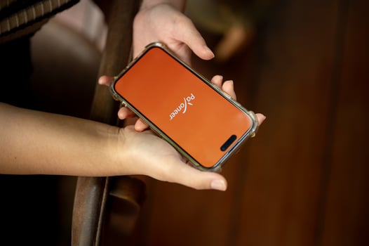 Payoneer logo on an iPhone14 screen, a woman using the Payoneer application on her smartphone. photo