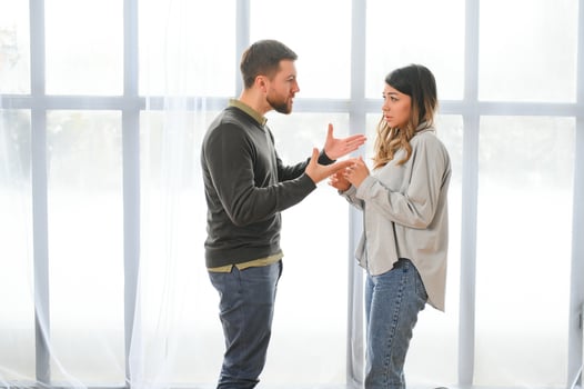 An agitated and upset husband shouts and looks at his wife, a quarrel between spouses. Family misunderstanding, quarrel photo