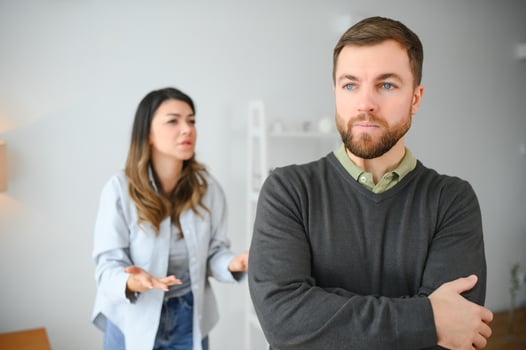 Family quarrel, man and woman sitting on sofa at home. angry woman yells at her husband photo