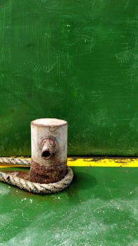 Rusty mooring bollard with ship ropes photo