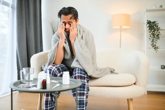 Sick young hindu man feeling bad in the morning, sitting on bed photo