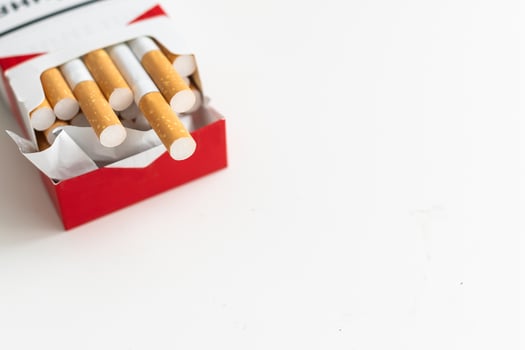 Open blue pack of cigarettes isolated on white background. Box of cigarettes closeup. photo