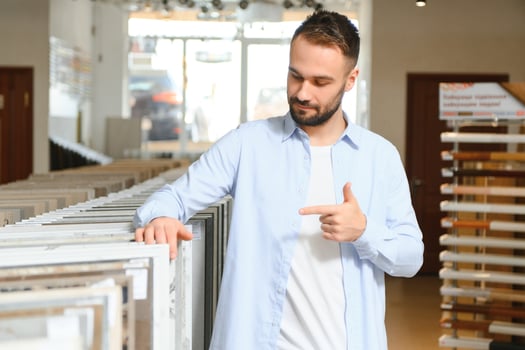 Young man choosing tiles at building market photo