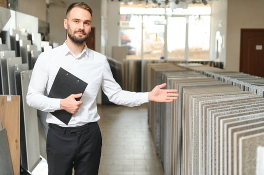 Portrait of a ceramic tile seller. The seller stands against the background of a large assortment of tiles photo