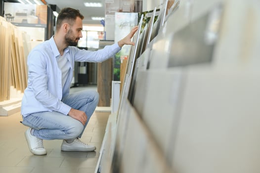 man choosing ceramic tiles and utensils for his home bathroom photo
