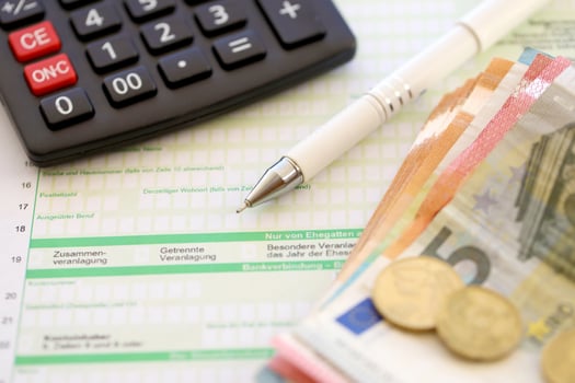 Filling german tax form process with pen and euro money bills close up. Tax paying period photo