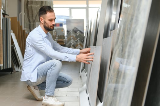 man choosing ceramic tiles and utensils for his home bathroom photo