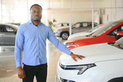 Handsome African man choosing a new car at the dealership photo