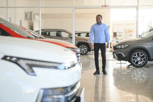 Car Buyer. Black Guy Choosing New Automobile In Dealership Store photo