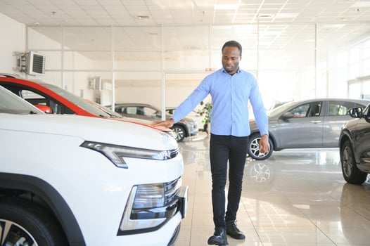 Car Buyer. Black Guy Choosing New Automobile In Dealership Store photo