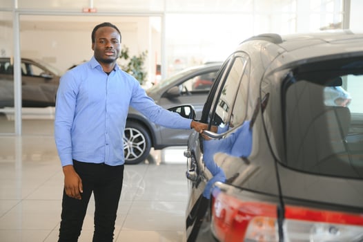 Handsome man is standing near his new car and smiling photo