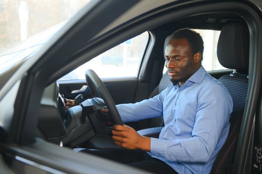 Handsome African man choosing a new car at the dealership photo