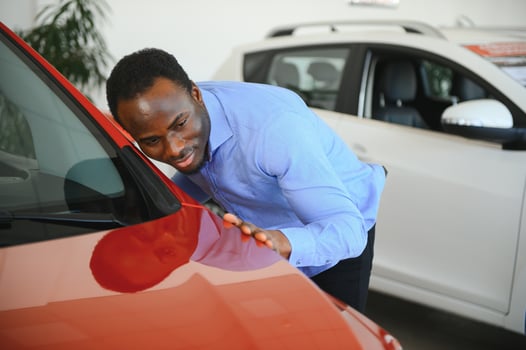 young africanamerican man came to see automobiles in dealership or cars showroom photo