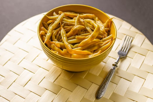 Fried long french beans in yellow ceramics cup. photo