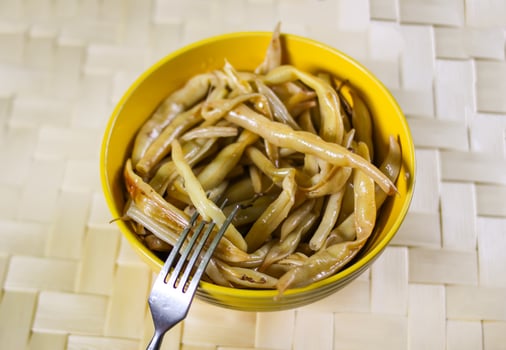 Fried long french beans in yellow ceramics cup. photo
