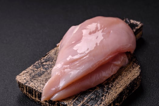 Fresh chicken fillet on a dark concrete table with spices and herbs photo