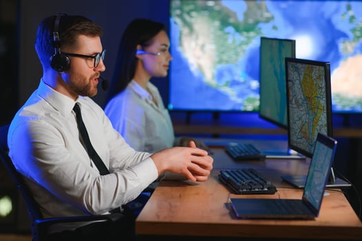 Male Data Scientist Works on Personal Computer Control and Monitoring Room. Map Surveillance of People Walking on City Streets photo