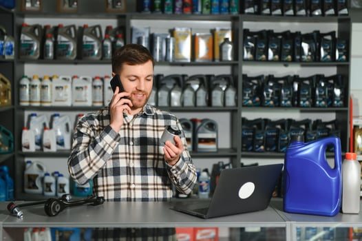 A salesman in an auto parts store is talking to a customer on the phone photo