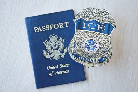 KYIV, UKRAINE - MARCH 9, 2024 US ICE Officer badge and United States passport on wooden table photo