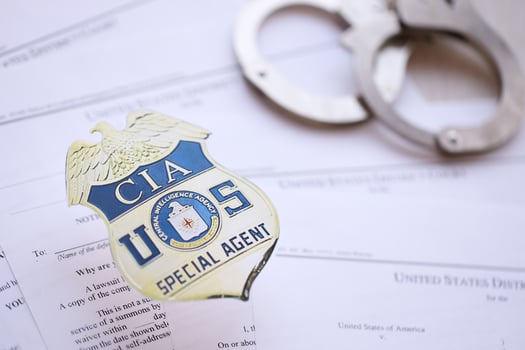 KYIV, UKRAINE - MARCH 9, 2024 US CIA Central Intelligence Agency badge with handcuffs on many US District Court warrants and complaints photo