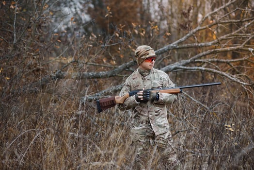 Hunter handsome guy with weapon. Hunter spend leisure hunting. Hunting equipment. Brutal masculine hobby. Man observing nature background. Hunter hold rifle. Safety measures. Natural environment photo