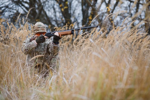 Hunter in uniform with a hunting rifle. Hunting Concept. photo