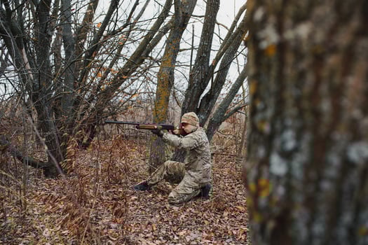 Hunter in uniform with a hunting rifle. Hunting Concept. photo