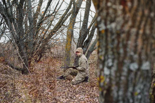 Hunter in uniform with a hunting rifle. Hunting Concept. photo