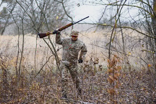 Hunter in uniform with a hunting rifle. Hunting Concept. photo