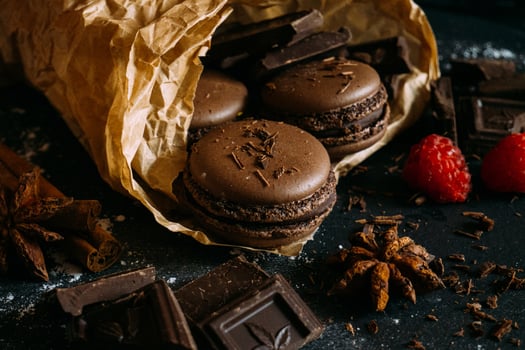 Macaroons with berries, chocolate and badiane on a black background photo