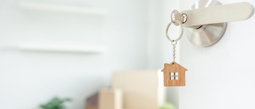 Moving house, relocation. The key was inserted into the door of the new house, inside the room was a cardboard box containing personal belongings and furniture. move in the apartment or condominium photo