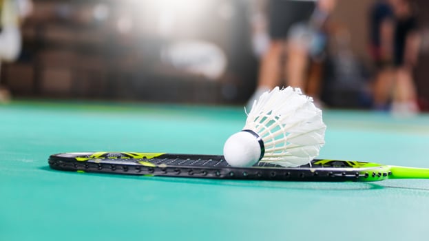 White badminton shuttlecocks and badminton rackets on green floor indoor badminton court soft and selective focus on shuttlecocks and the rackets photo