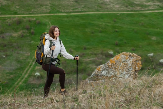 Young woman with backpack hiking in the mountains. Hiking concept. Trekking cliffs. Travel, traveler. photo