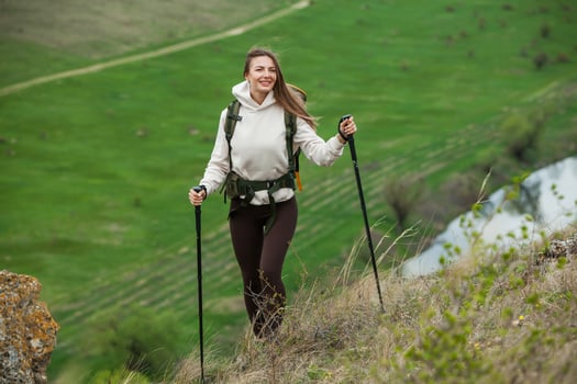 Young woman with backpack hiking in the mountains. Hiking concept. Trekking cliffs. Travel, traveler. photo