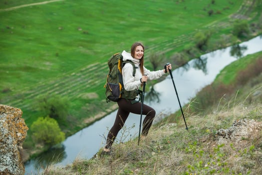 Young woman with backpack hiking in the mountains. Hiking concept. Trekking cliffs. Travel, traveler. photo