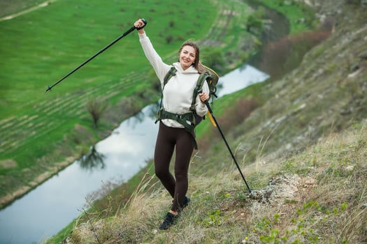 Young woman with backpack hiking in the mountains. Hiking concept. Trekking cliffs. Travel, traveler. photo
