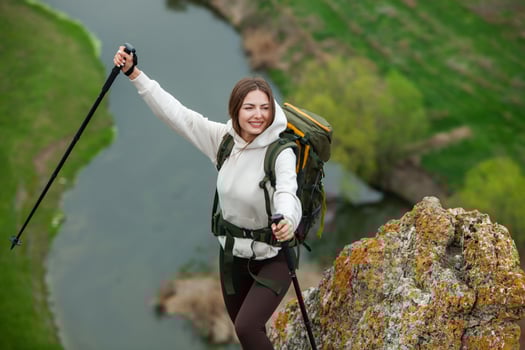 Young woman with backpack hiking in the mountains. Hiking concept. Trekking cliffs. Travel, traveler. photo