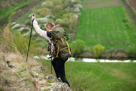 Young woman with backpack hiking in the mountains. Hiking concept. Trekking cliffs. Travel, traveler. photo