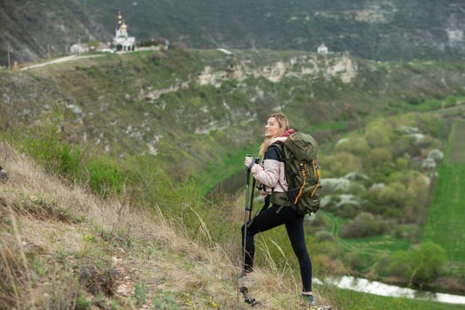 Young woman with backpack hiking in the mountains. Hiking concept. Trekking cliffs. Travel, traveler. photo