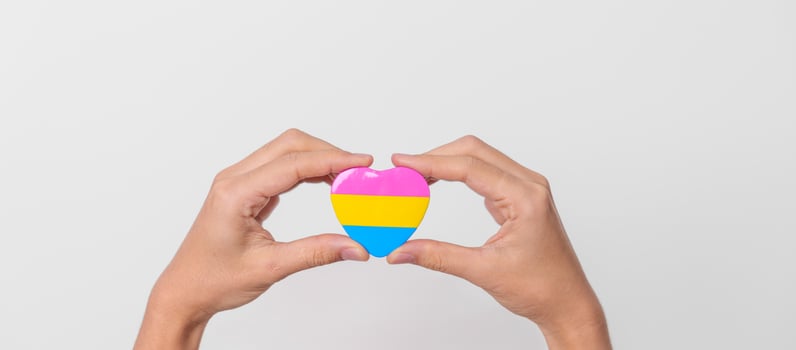 Pansexual Pride Day and LGBT pride month concept. hand holding pink, yellow and blue heart shape for Lesbian, Gay, Bisexual, Transgender, Queer and Pansexual community photo