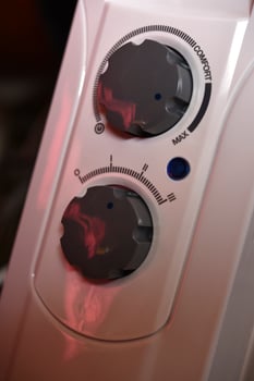 Round switches on a white radiator. The control panel. photo