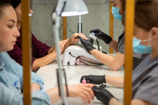 Two women getting a manicure treatment in beauty salon. photo